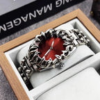 metal wristwatch with flame-shaped silver bezel and red dial, displayed in a wooden box